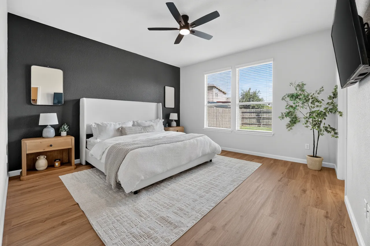 Freshly painted bedroom with a dark accent wall and new wood-look flooring