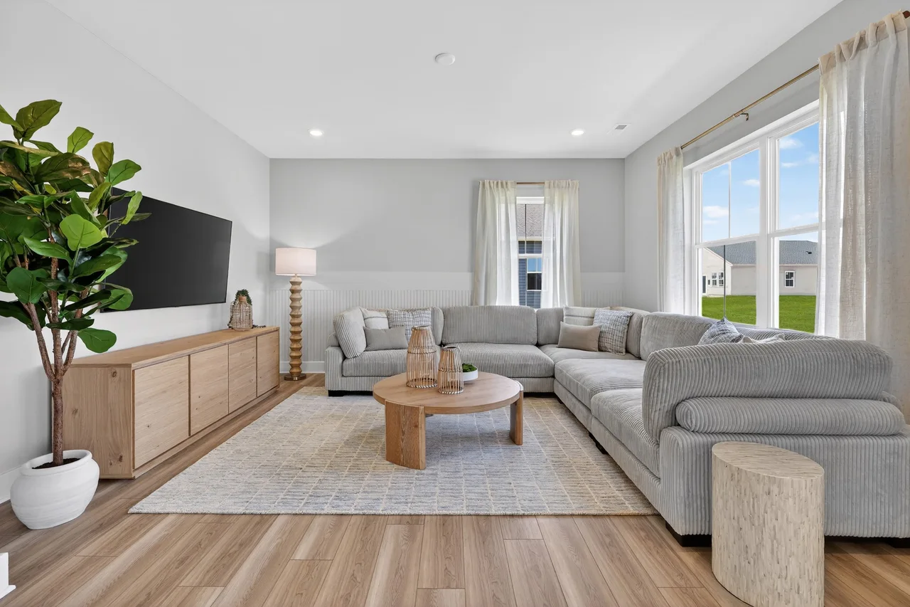 Virtually or professionally staged living room showing neutral furniture arrangement that helps buyers visualize a space