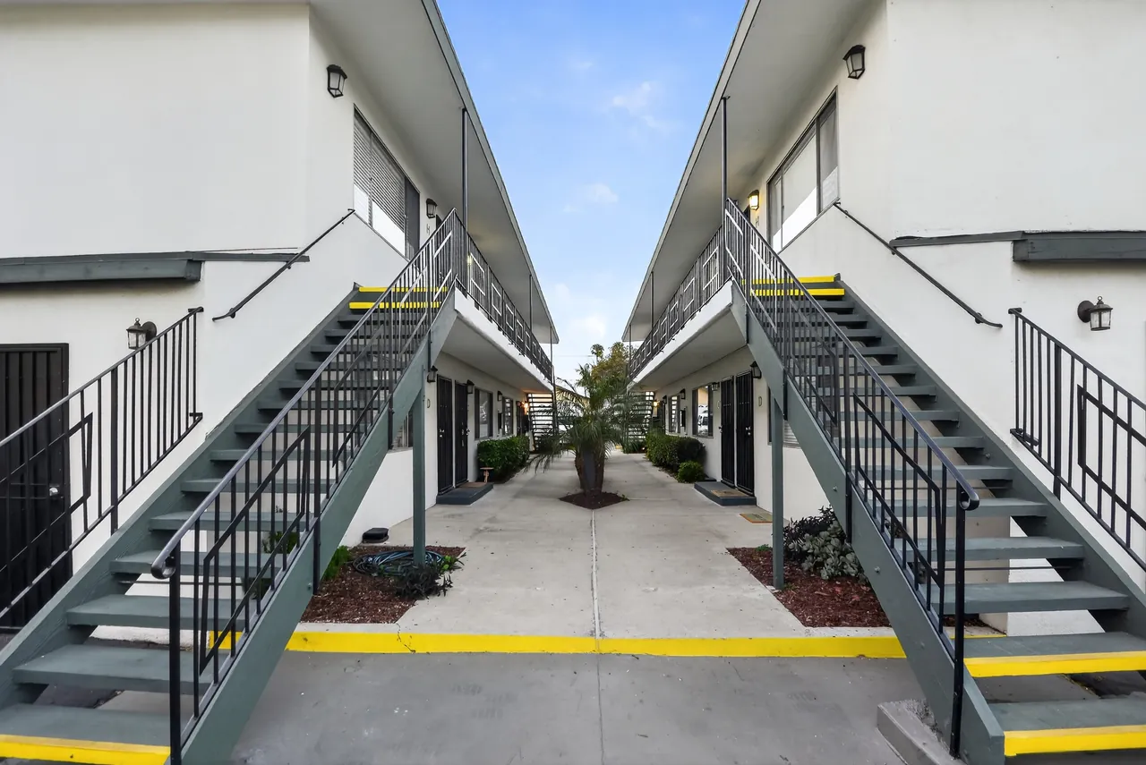Freshly maintained apartment courtyard with twin staircases, clean walkways and new landscaping