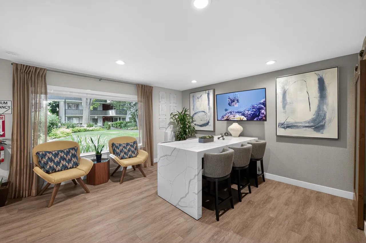 Updated lounge with a waterfall-edge counter, bar stools and lounge chairs, cleaned and staged for photography